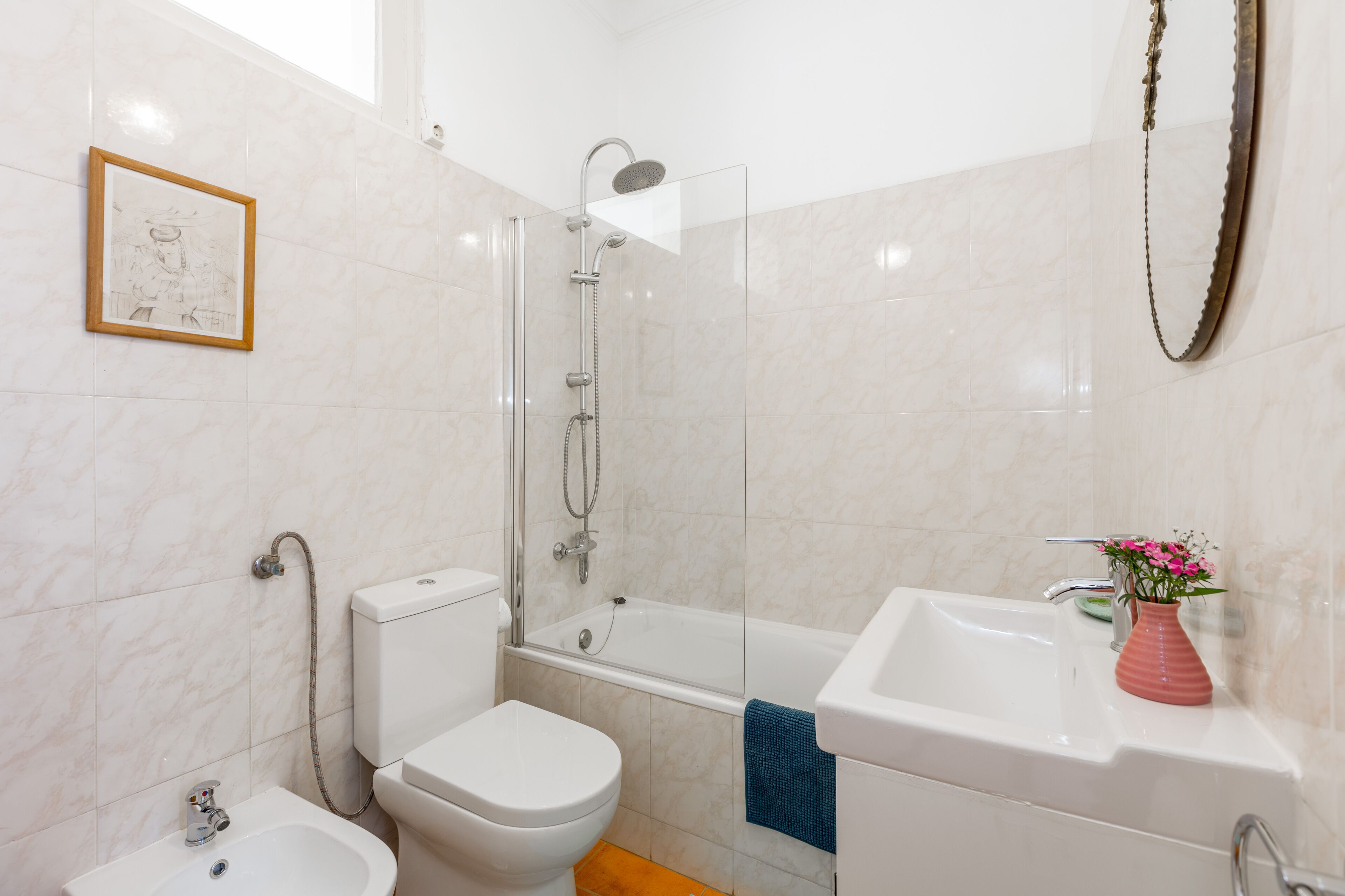A bathroom with a toilet, bidet, bathtub, and sink.