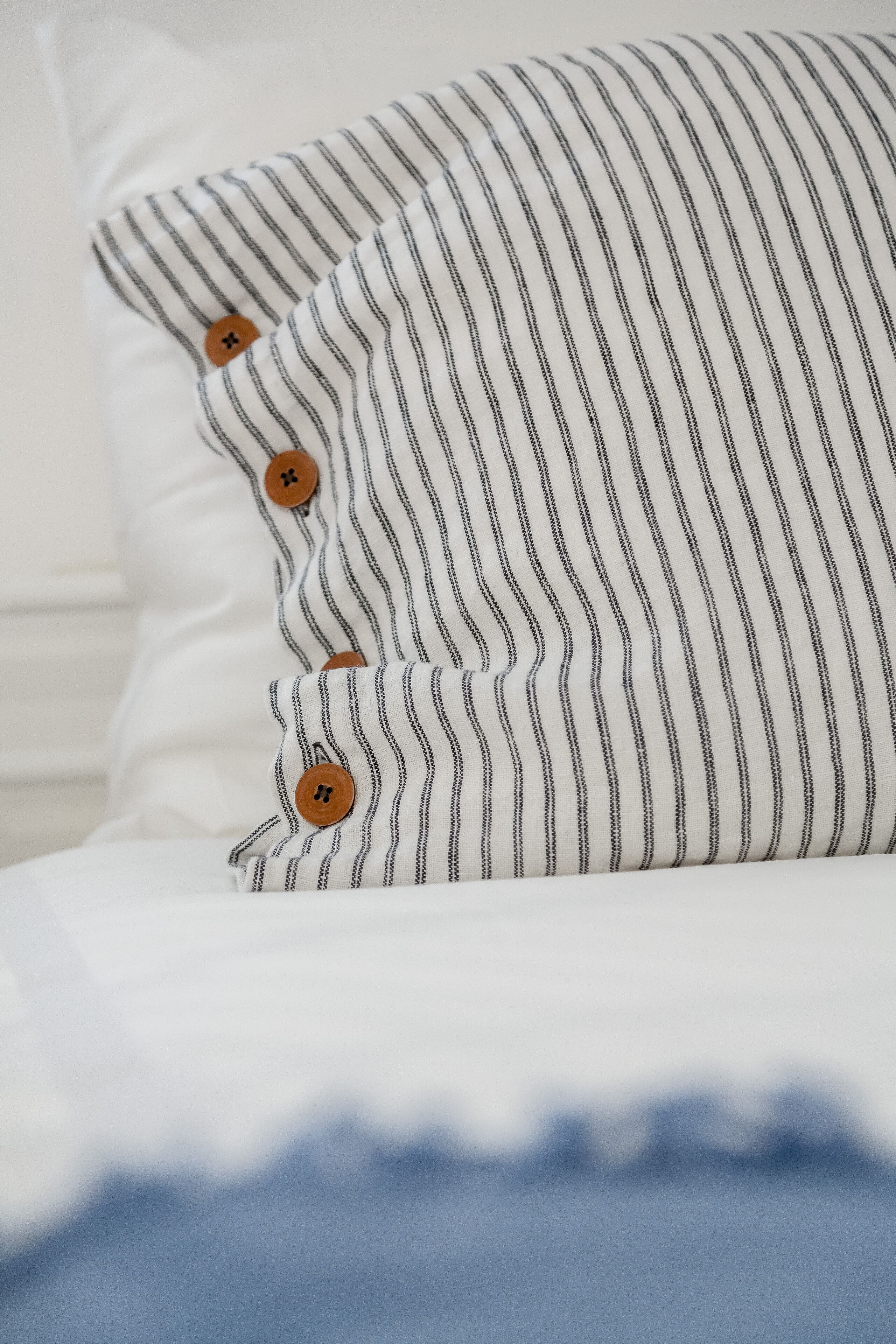 A pillow with a striped pattern and three brown buttons.