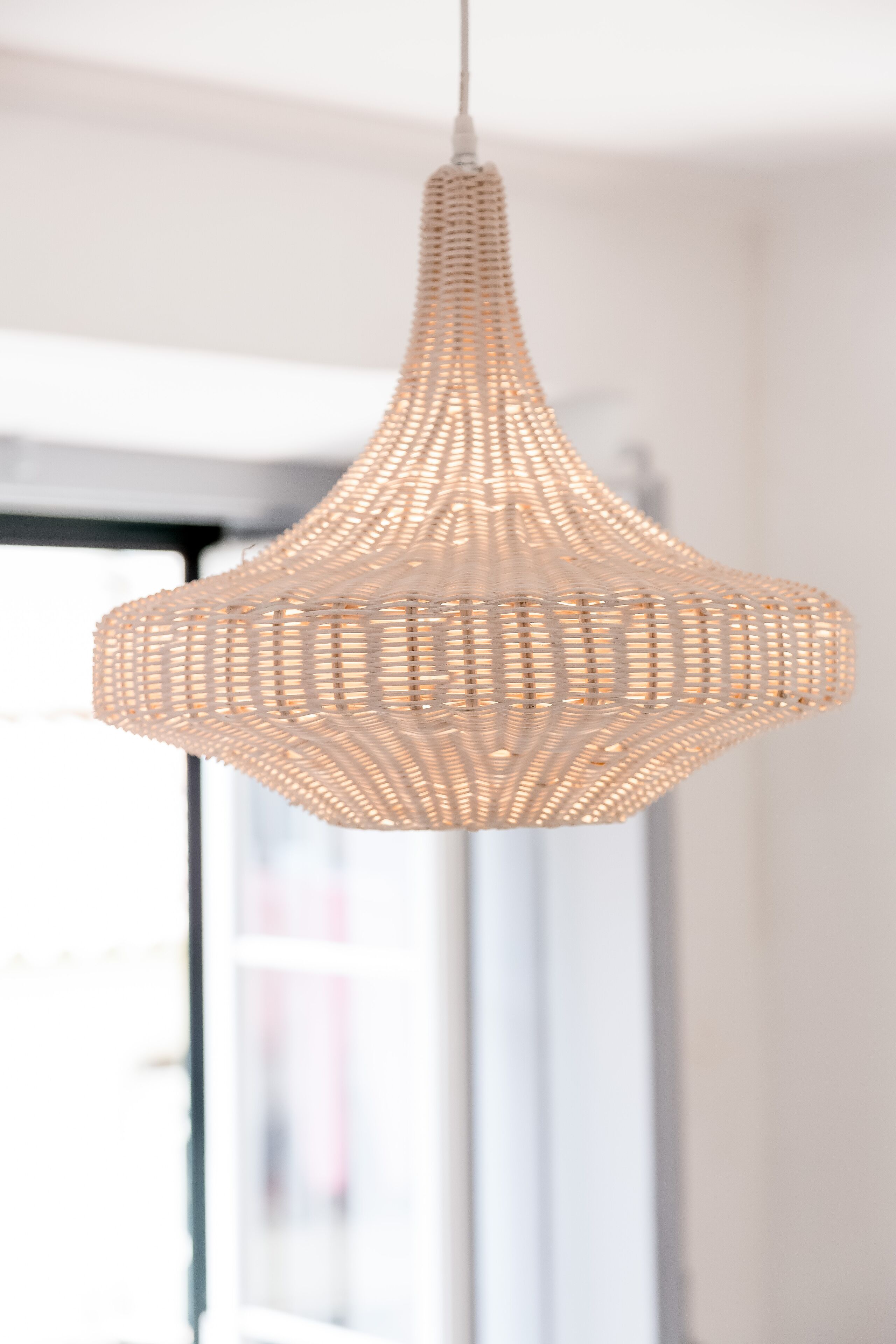 A hanging light fixture with a woven design.