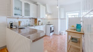 Una cocina moderna con armarios blancos, una isla central y horno empotrado.