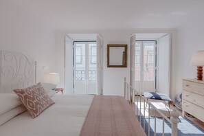 Un dormitorio con cama, mesita de noche, cómoda y ventana con vistas.