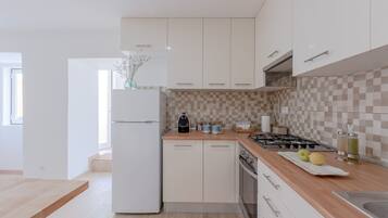 Apartamento, 3 quartos | Cozinha privada | Geladeira grande, fogão, cooktop, lava-louças