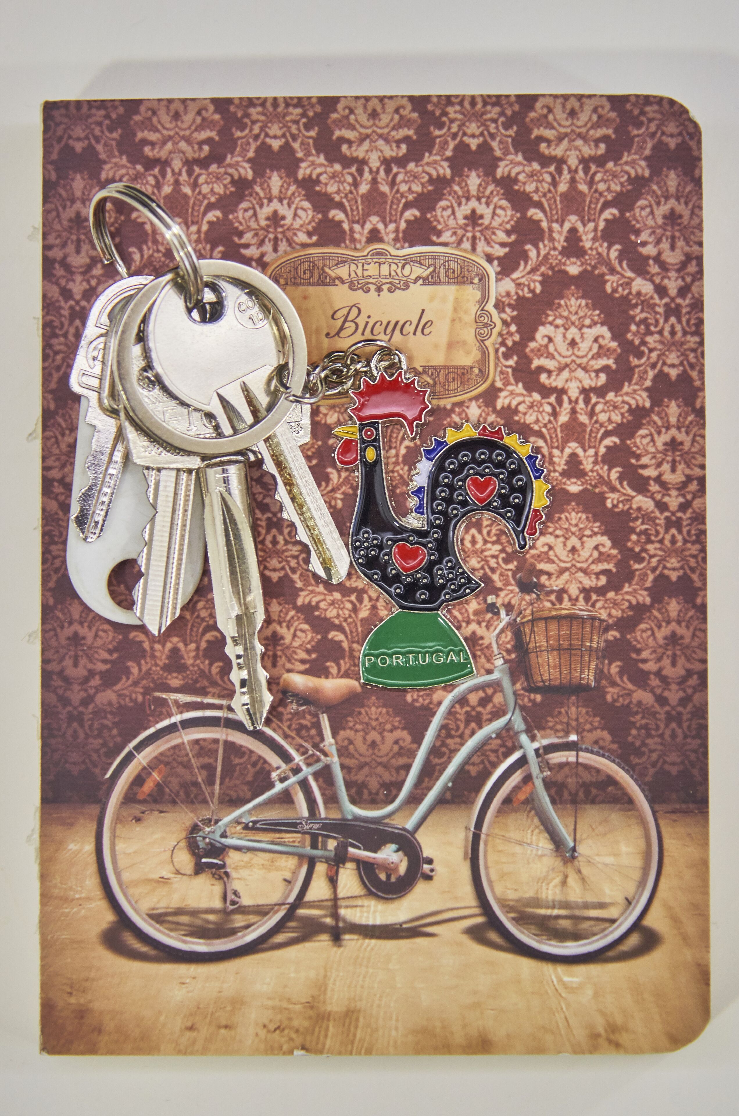 A vintage bicycle with a basket and a decorative rooster figure.