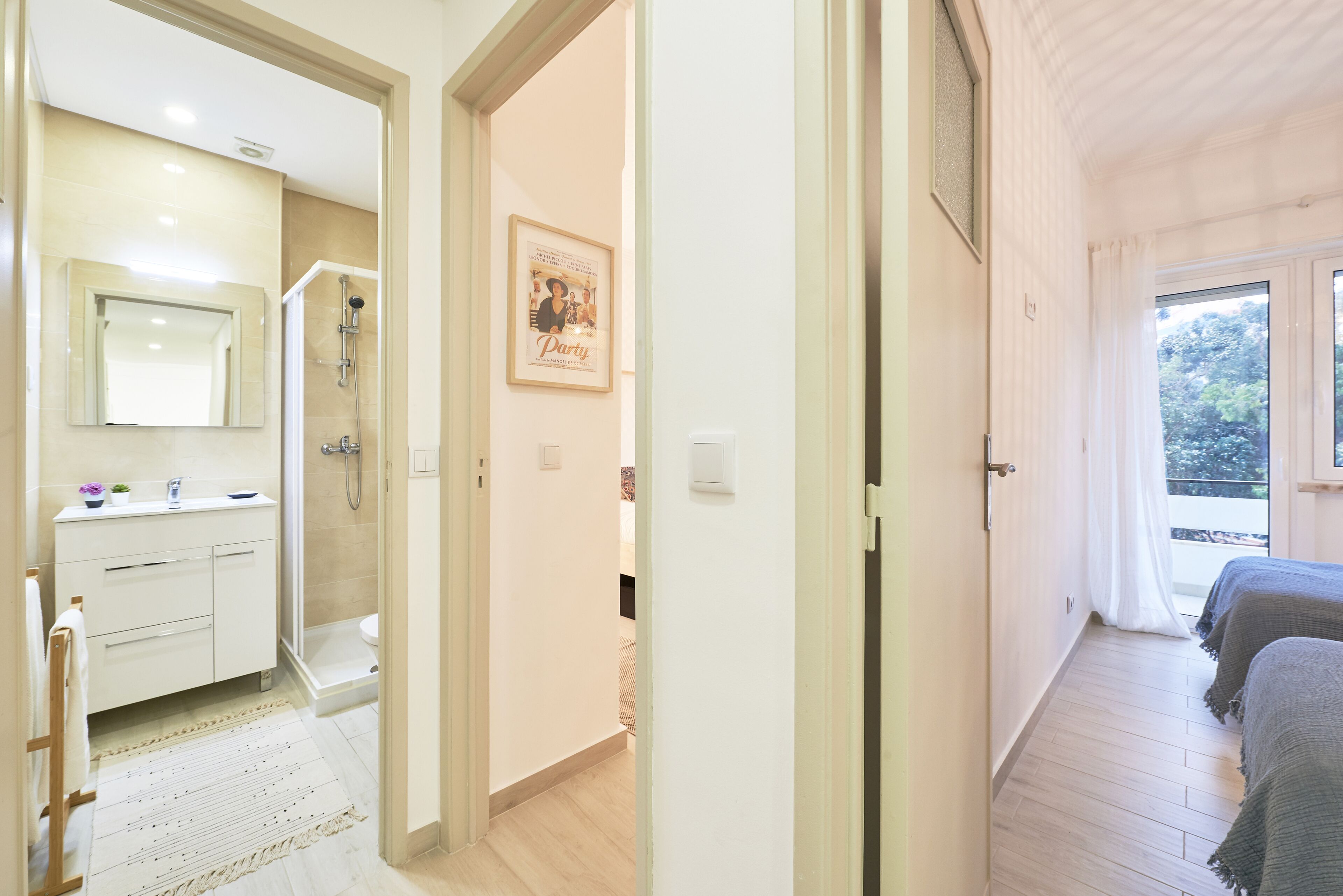 Hotelkamer met een badkamer, douche, bed en raam met uitzicht op bomen.
