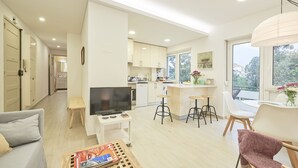 A modern apartment with a living room, kitchen, and dining area. - Light Apartment W/ Balcony Apartment by TimeCooler (Lisbon)