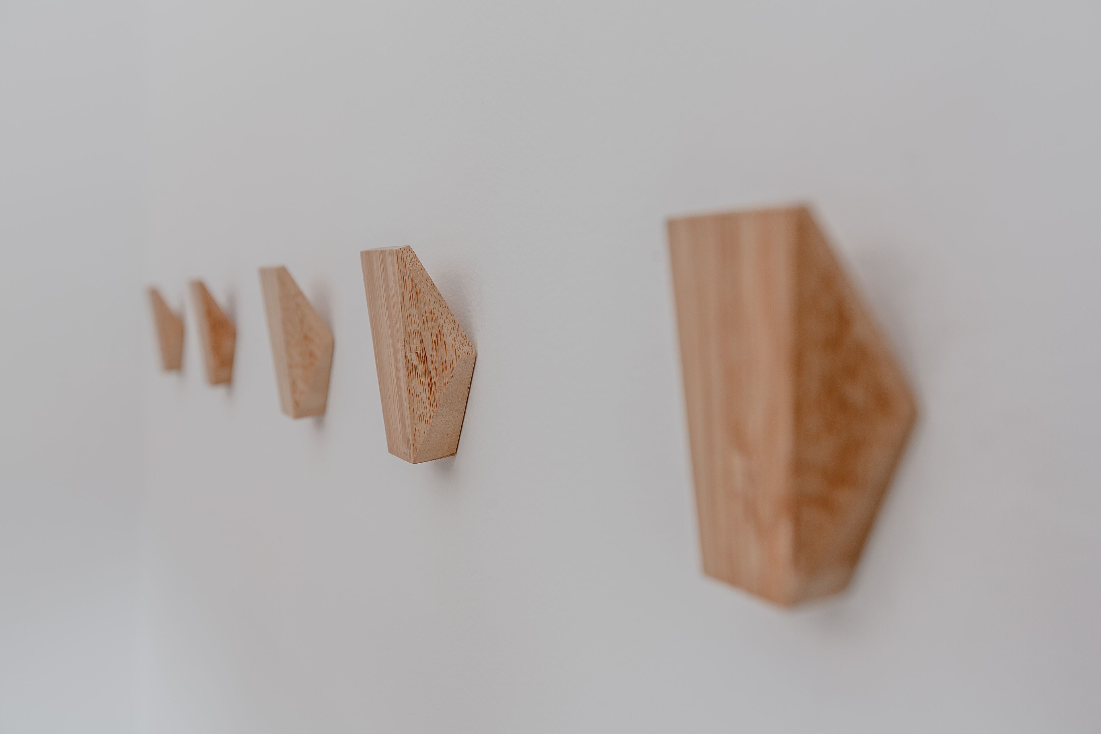 A series of wooden blocks of varying sizes arranged in a line on a white background.