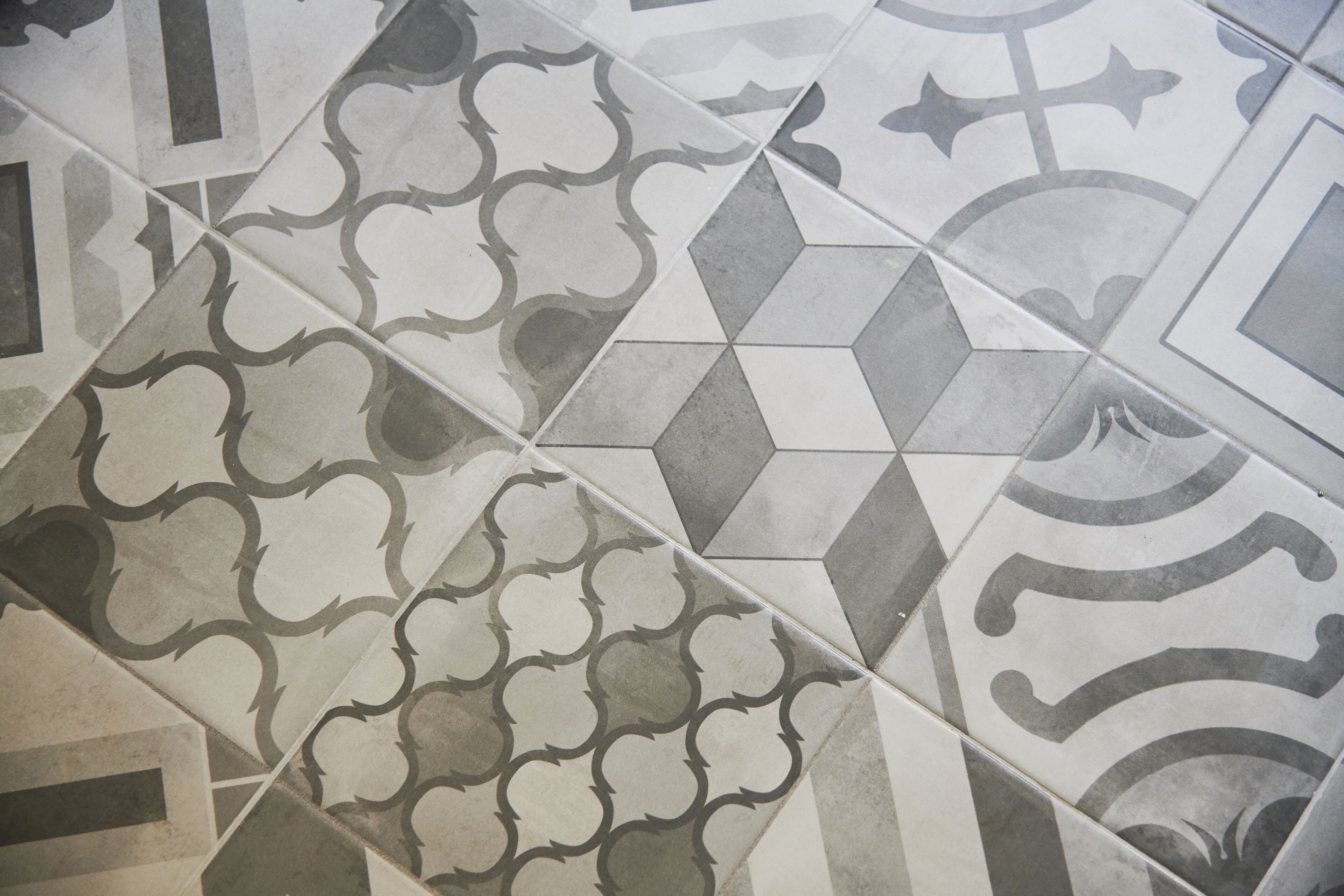 A close-up of a tiled floor with various geometric patterns and designs.