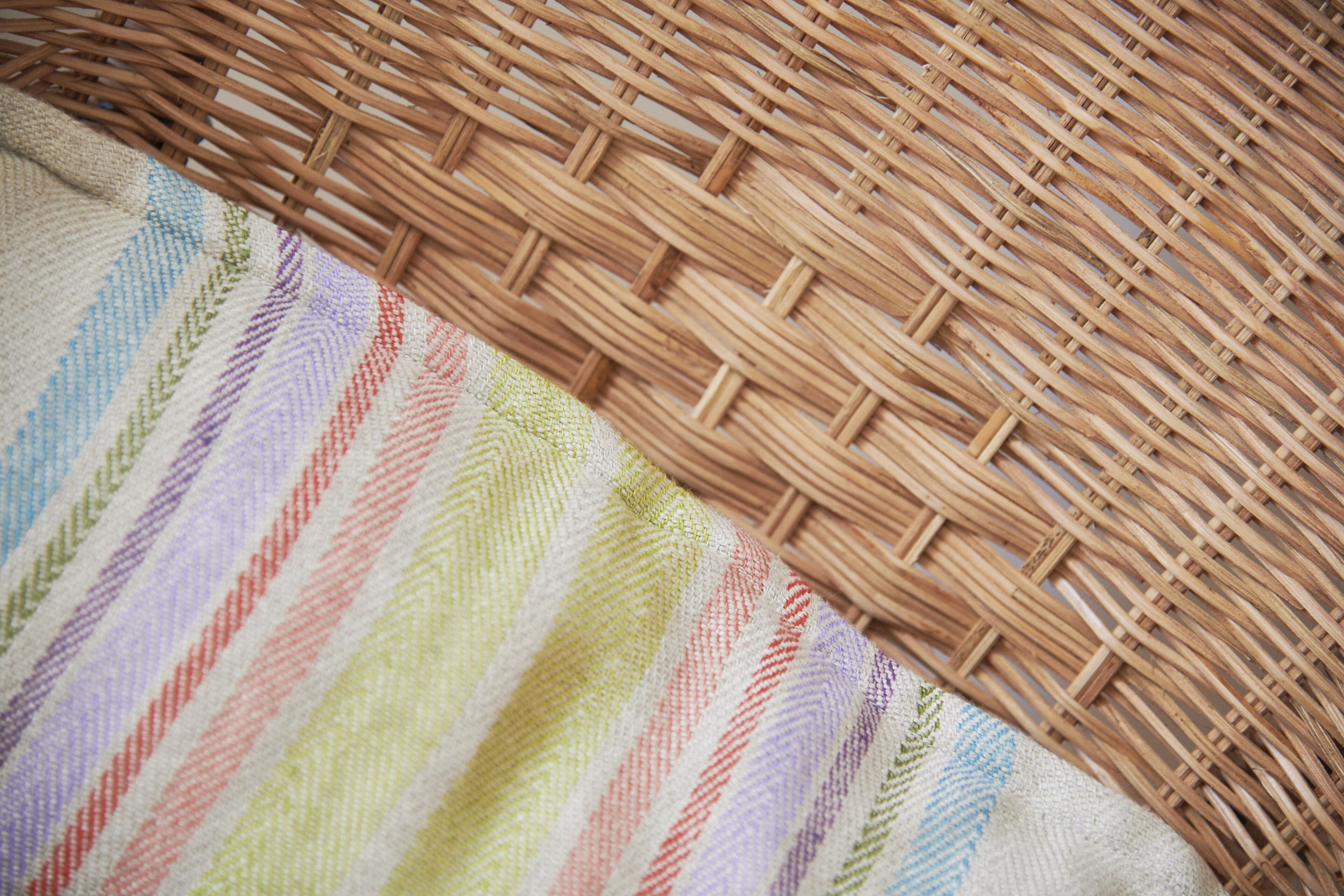 A woven basket with a colorful striped fabric partially covering it.