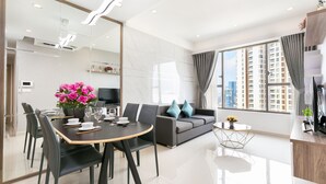 A modern living room with a dining area, a sofa, and a TV. - Rivergate Residence Apartments (Ho Chi Minh City)