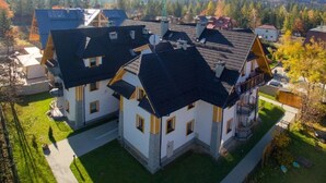 Área residencial com várias casas, uma grua de construção visível e montanhas ao fundo.