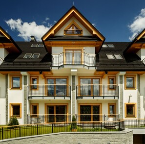 A two-story house with a balcony, large windows, and a stone facade. - Apart-Center Pod Orlem II (Zakopane)