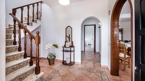 Un escalier orné de balustrades travaillées, un miroir et un motif décoratif sur le sol.