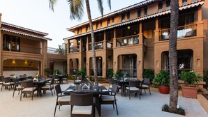 Un patio con mobiliario exterior y un edificio con varios balcones.