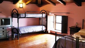 A room with bunk beds, a television, a window, and a bedside table with a lamp. - Fattoria Alvaneta (Padula)