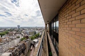 A high-rise building with a view of a cityscape, including various buildings and a train track. - Point West Apartments (London)