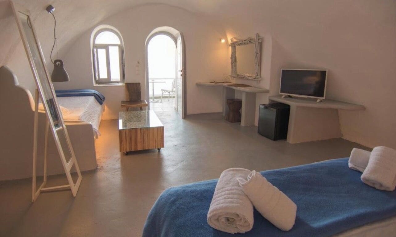 A room with a bed, a desk, a television, and a window.