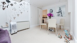 Ein modernes Interieur mit einer Treppe, weißen Wänden und einem Essbereich mit Stühlen und einem Tisch.