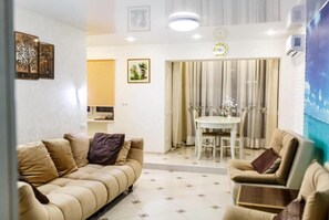 Relax in this stylish living room with a sofa, armchair, and dining area.