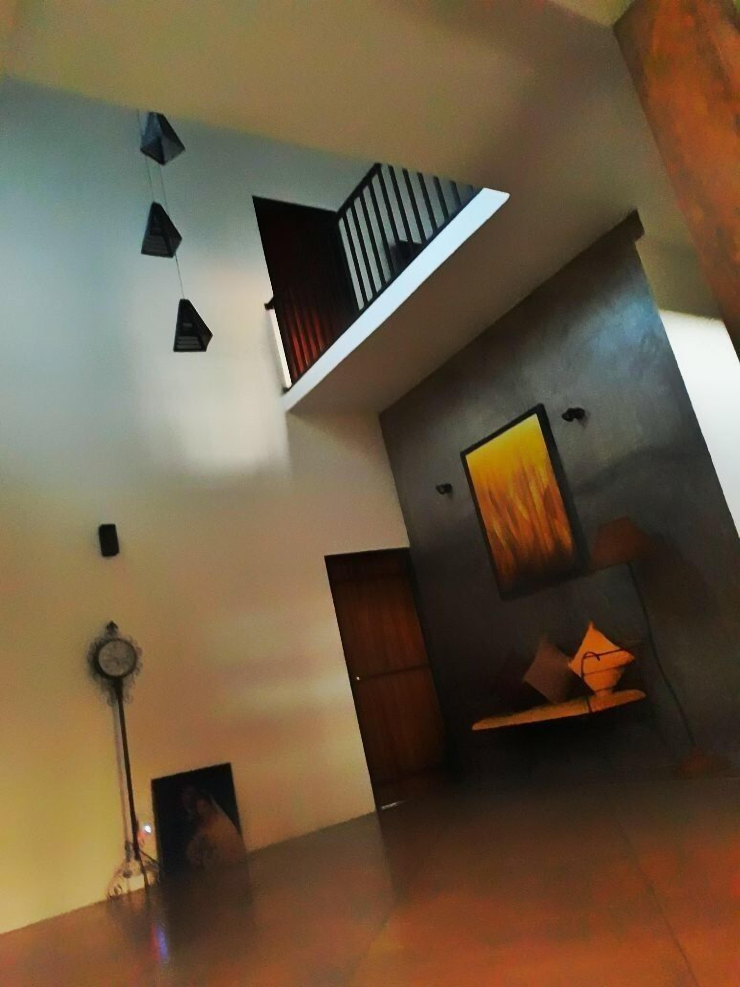 Un interior moderno con techo estilo loft, un sofá de tonos oscuros y una decoración minimalista.