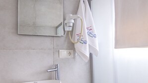 Kylpyhuoneessa on valkoinen pesuallas, puinen taso ja peili, joka on sijoitettu pesualtaan yläpuolelle.