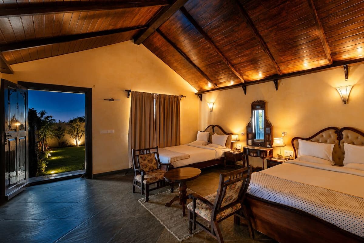 Een hotelkamer met twee bedden, een eettafel, een stoel en uitzicht op het landschap.