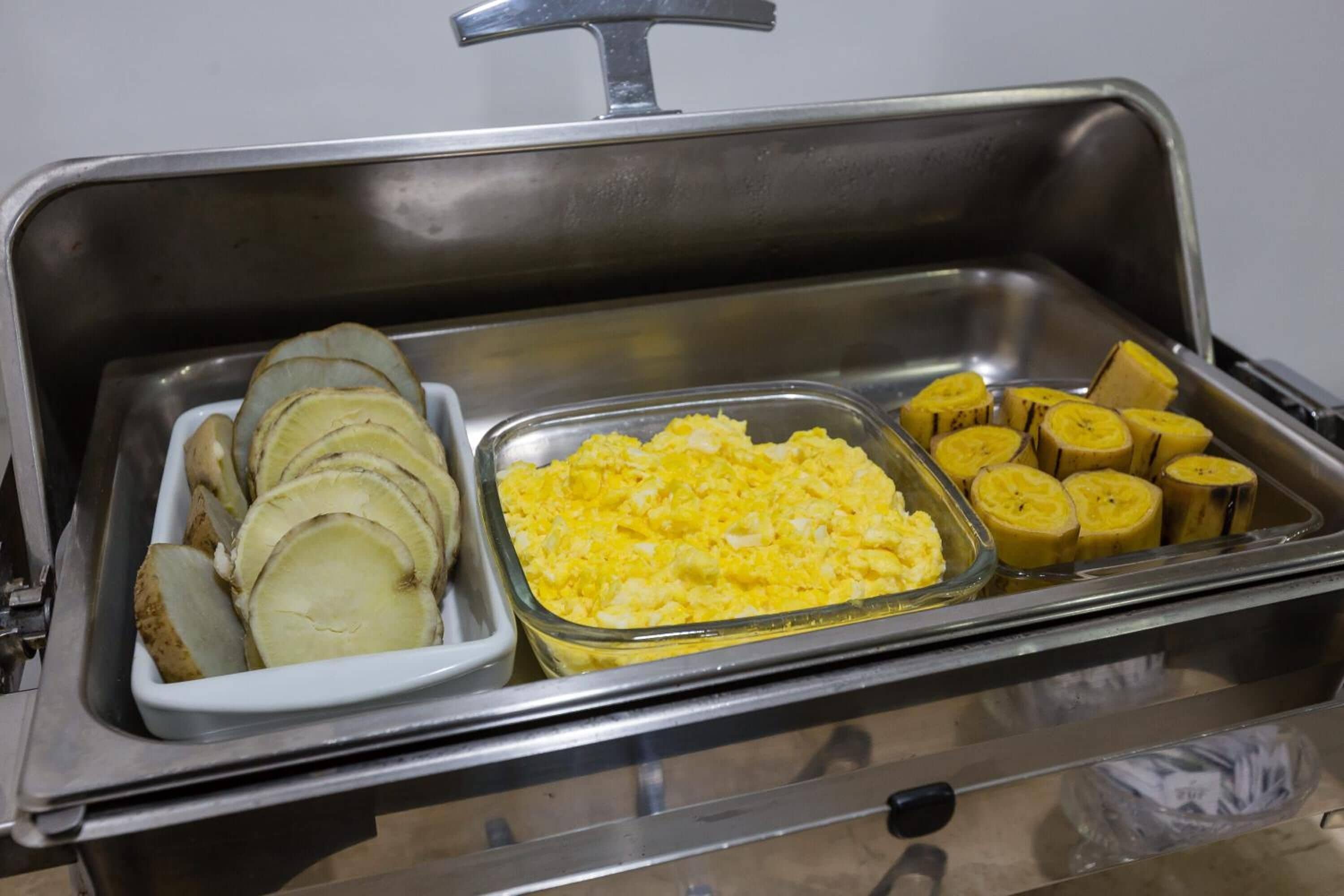 Un buffet proposant des pommes de terre en tranches et des œufs brouillés.