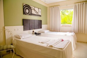 A hotel room with two beds, a large window with curtains, a wall-mounted artwork, and a chair. - Eunapolis Plaza Hotel (Eunapolis)