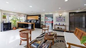 Una sala de estar moderna con comedor, cocina y un refrigerador grande.