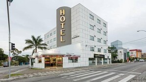 Un hotel moderno con un llamativo letrero que dice 'HOTEL', un restaurante en la planta baja y una fachada limpia y contemporánea.