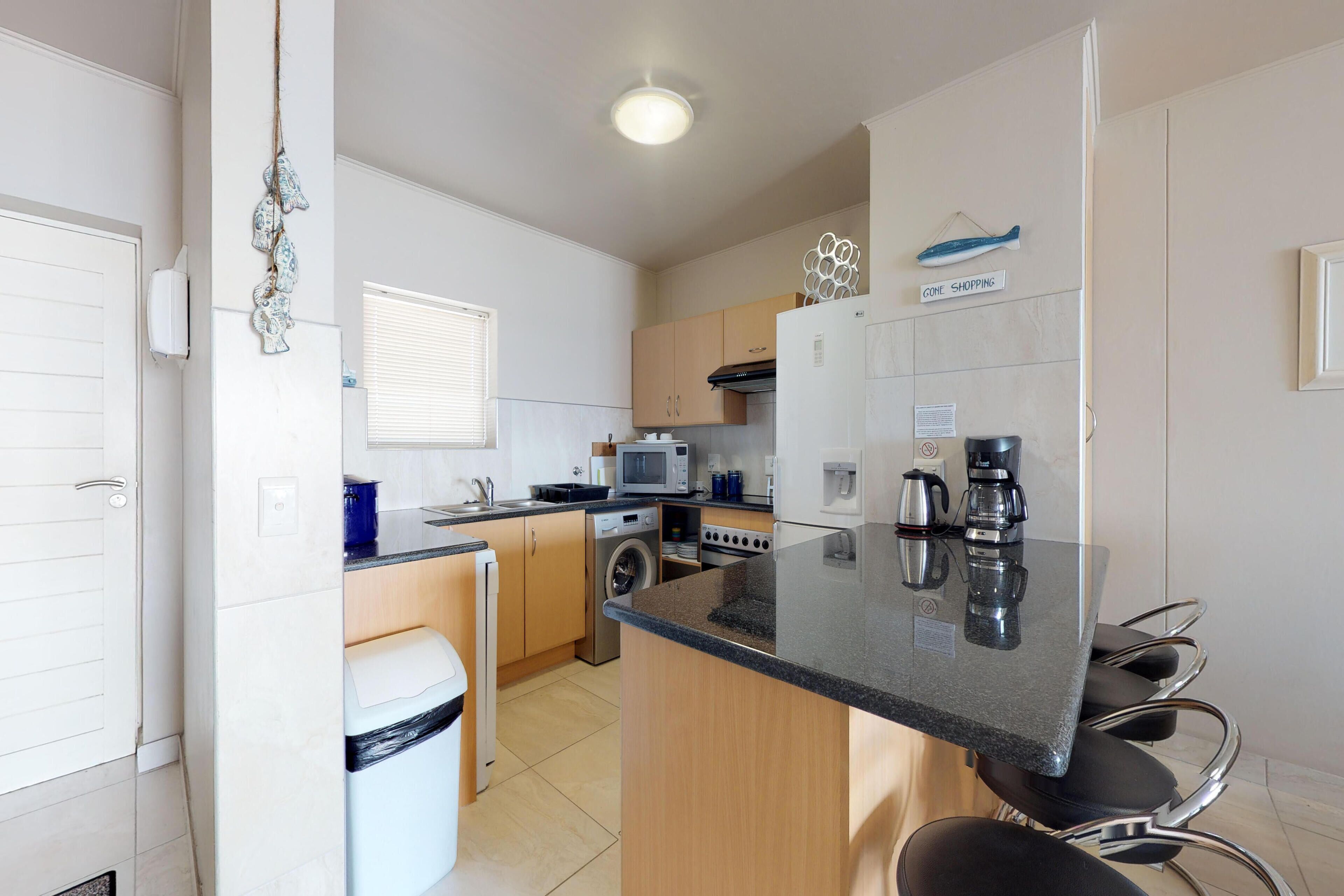 A compact kitchen with a central island, built-in appliances, and a small seating area.