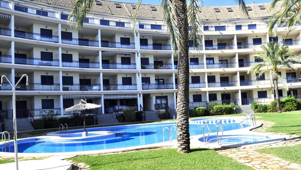 A hotel with multiple balconies, a swimming pool, and palm trees. - Sueños De Denia, 2 bedrooms, by Bookindenia (Denia)