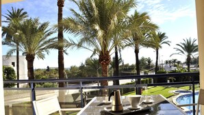 A balcony with a table, a coffee pot, and a cup, overlooking a pool and palm trees. - Sueños De Denia, 2 bedrooms, by Bookindenia (Denia)