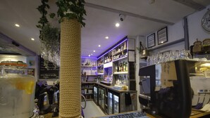 Eine Bar mit Regalen voller Flaschen, einer Kaffeemaschine und einem großen Getränkespender.