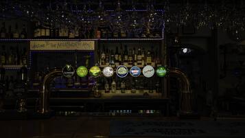A bar with a variety of liquor bottles and a selection of beer taps.