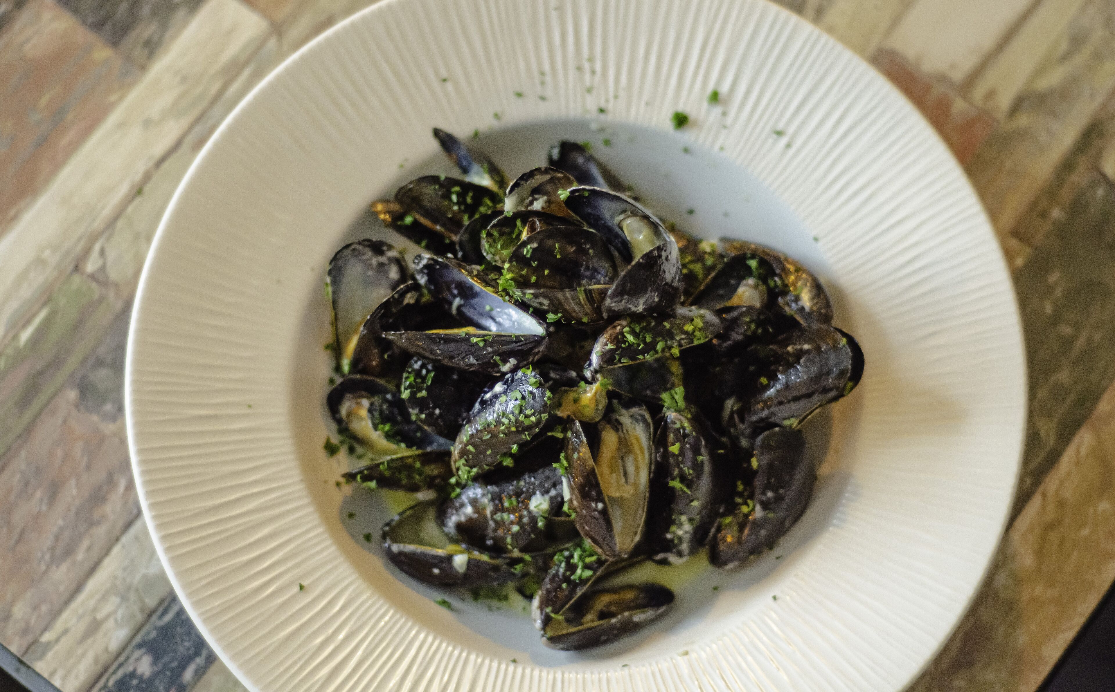 Un plato de mejillones adornados con hierbas.