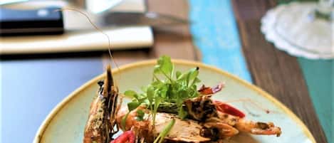 A plate of grilled fish with lemon and herbs on a ceramic plate.