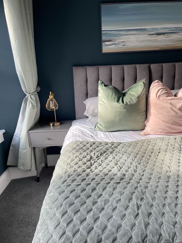 A bedroom with a bed, a nightstand, a lamp, and a painting on the wall. - Molesworth Arms (Wadebridge)