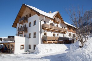 A multi-story hotel with wooden balconies and a snow-covered roof.