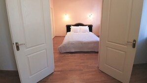 A bedroom with a bed, two bedside lamps, and a wooden floor. - WINWINSTAY Old Town Riverside Apartment (Riga)