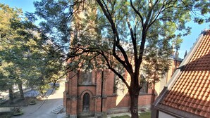 A brick building with a large arched window and a tree in front. - WINWINSTAY Old Town Riverside Apartment (Riga)