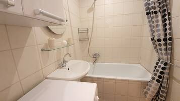 Un baño con lavamanos, espejo y ducha.