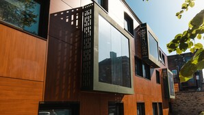 Un bâtiment moderne doté de grandes fenêtres et d’une façade en bois.