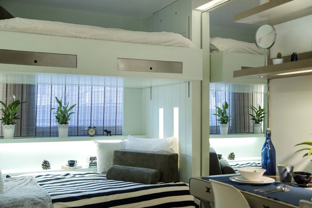 Un dormitorio moderno con cama, mesita de noche y un espejo grande.