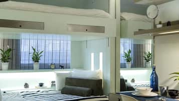 Un dormitorio moderno con cama, mesita de noche y un espejo grande.