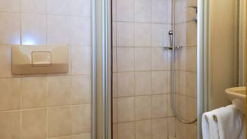 Ein Badezimmer mit Toilette, Duschkabine und Waschbecken mit Handtuch.
