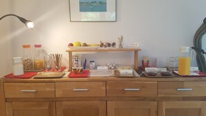 Un comptoir de petit-déjeuner avec divers aliments et condiments, un tableau encadré au mur et un cactus dans un coin.