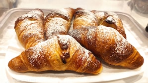 A tray of freshly baked croissants dusted with powdered sugar. - Palazzo Verdi B&B (Viterbo)