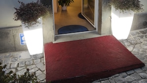 A hotel entrance with a red carpet, a glass door, and a sign reading "PALAZZO VERDI". - Palazzo Verdi B&B (Viterbo)