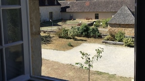 A view from a window overlooking a rural village with traditional houses and a gravel courtyard. - Picturesque village,  2 amazing restaurants, creperie and shops a few steps away (Daglan)