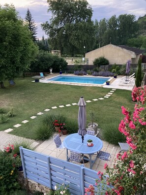 A backyard with a swimming pool, a patio table, and a blue lawn chair. - Picturesque village, 2 amazing restaurants, creperie and shops a few steps away (Daglan)